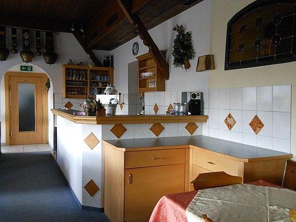 Gemütliche Theke der Gaststube im Café Obladis mit Holzvertäfelung und Kaffeemaschine