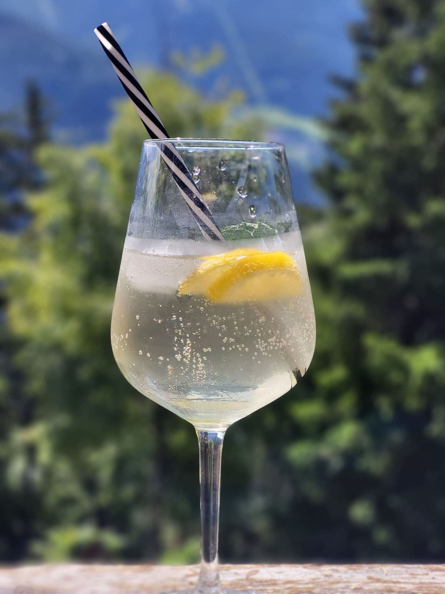Erfrischender Spritzer mit Zitrone vor Bergkulisse auf der Terrasse des Café Obladis